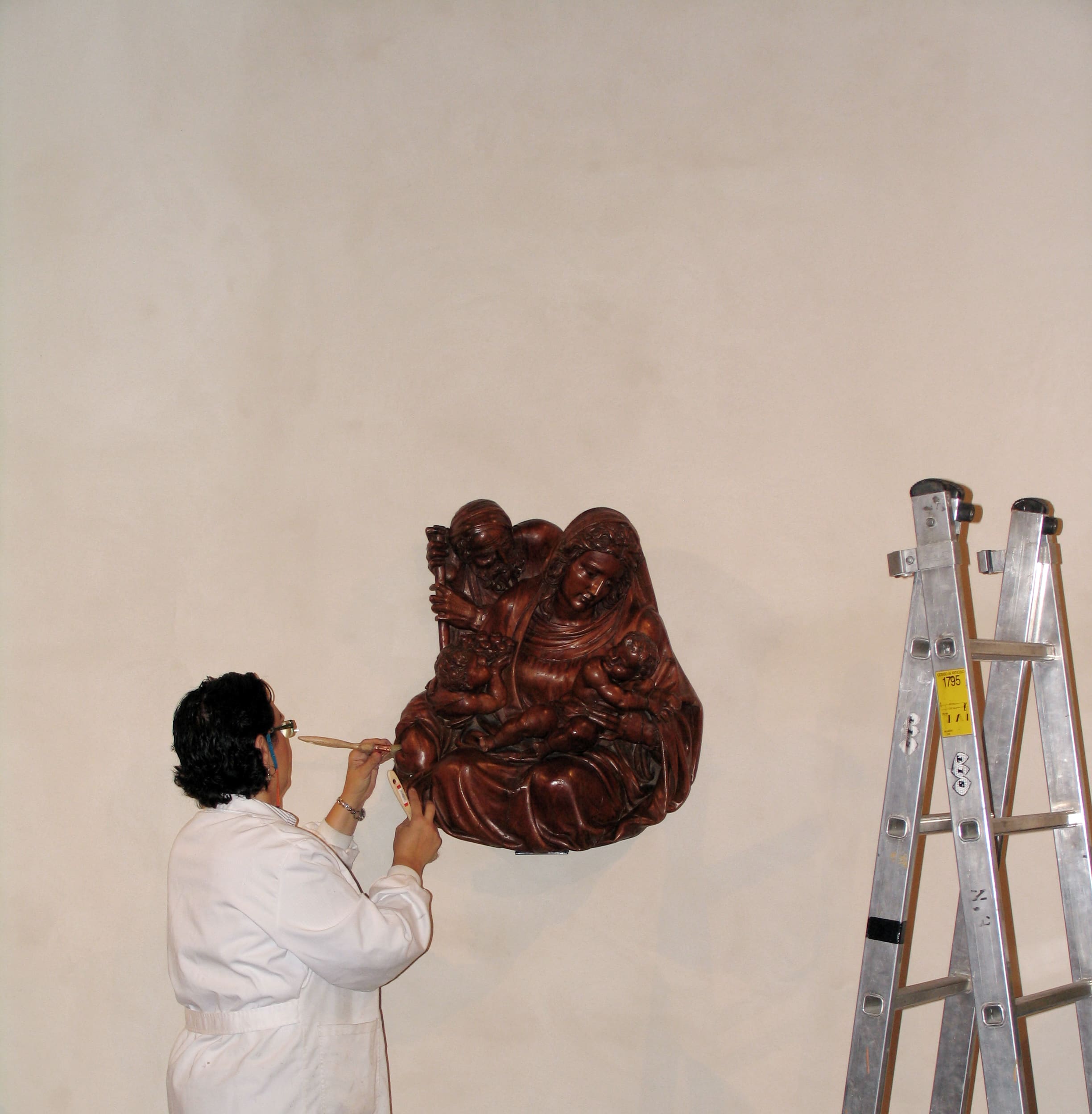 Restauradora trabajando sobre talla de madera